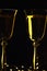 Contour of glasses with champagne on a dark background. Golden color and sparkling champagne. Celebration atmosphere.