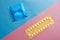 Contraception pills and condom on blue and pink background.