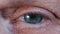 Contraction of the pupil. Beautiful blue eye iris of middle-aged woman. Peepers of old grandmother with wrinkles. Macro