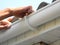 Contractor installing plastic roof gutter. Plastic Roof Guttering Renovation, Rain Guttering Repair & Drainage