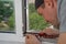 A contractor master adjusts and repair in house plastic windows.