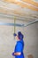 Contractor with measuring tape Installing Garage Door Post Rail