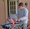 Contractor measuring tiles before cutting