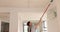 Contractor paints ceiling with roller brush on long handle