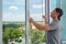 A contractor worker installing mosquito wire screen on house plastic windows to protect from insects.