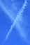 Contrail of airplane on blue sky - vertical - portrait