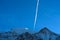 Contrail of an airplane over a snowy mountain