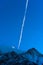 Contrail of an airplane over a snowy mountain