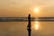 Contrast silhouette of a young slender woman against the background of a Sunny sunset, the sea and the sandy beach.