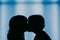 Contrasting silhouette of two girls kissing
