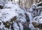 Contrasts of frozen and running water, spring water flows over pieces of limestone, running water freezes to form various