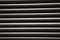 Contrasty abstract close up filled frame background wallpaper shot of grey window blinds with rays of light shining through and