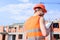 Control construction process. Builder orange vest and helmet works at construction site. Contractor control according to
