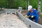 A control worker makes a measurement of the quality of the road construction course