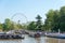 Controversial big ferris wheel with several pleasure and narrow boats underneath during Engllish summer