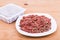 Convenient packaged minced raw meat dog food on plate