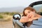 Convertible car owner resting contemplating views in the mountain