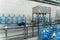 Conveyor belt, water in big blue bottles or gallons, beverage factory interior, industrial production line