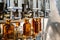 Conveyor carries glass bottles of luxury cognac in workshop