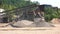 Conveyor and pile of gravel at industrial plant.