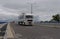 Convoy of large trucks drive on a highway with mid-cloudy background