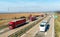 Convoy of Red transportation Trucks in line passing two white buses on a countryside highway