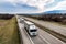 Convoy of Three White transportation trucks in line on a country highway at sunset