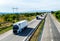 Convoy of transportation Lorry trucks in line passing on a country highway