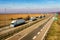 Convoy of White transportation trucks in line on a countryside highway