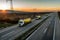 Convoy of white and yellow Tank trucks on a Highway Road traffic at sunset