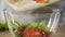 Cook adding chopped vegetables to bowl with lettuce, making fresh vitamin salad