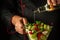 The cook adds olive oil to a vitamin salad for lunch. The concept of preparing a vegetarian dish with the hands of a chef.