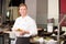 Cook or chef from catering service posing with food at buffet