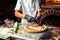 Cook Chef making delicious pizza at the restaurant, close-up