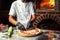 Cook Chef making delicious pizza at the restaurant, close-up