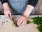 Cook chopping potherbs on wooden cutting board