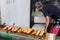 A Cook Is Cooking Tuna Sticks On A Fish Market