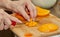 Cook cuts juicy mango into slices for making salad