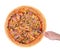 The cook cuts the tasty pizza with chicken breast, corn, bacon and mushrooms, with a pizza cutter on a wooden plate, isolated