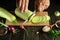 The cook cuts the zucchini into small pieces with a knife before preparing a delicious diet lunch with vegetables