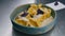 Cook decorates plate with ravioli in cream sauce