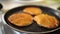 The cook flips the pancakes in the pan with a spatula, close-up.