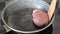 Cook fries ribeye beef steak in a pan