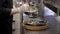 A cook in gloves lays oysters from a deep bowl in a flat iron dish.