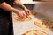 Cook hands adding champignons to pizza at pizzeria