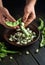 The cook hands separate the beans from the green pods. Preparation for cooking vegetarian food on the kitchen table