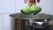 A cook or housewife puts fresh broccoli in a pot of boiling water.