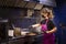 Cook with mask in the kitchen of a restaurant preparing meals