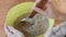 Cook mixes ingredients for dough in plastic bowl