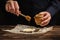 The cook pours honey on bread